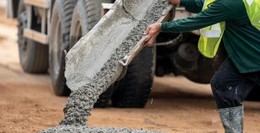 construction-worker-pouring-wet-concret-road-construction-site-370x190